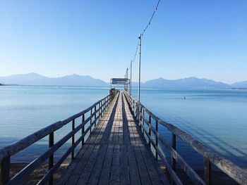 View of jetty leading to calm sea