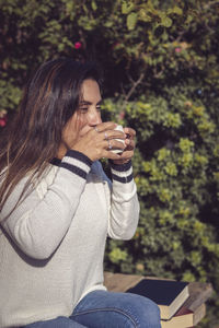 Moment of tranquility latina woman drinking coffee in the garden