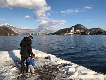 Man with son standing on pier during winter