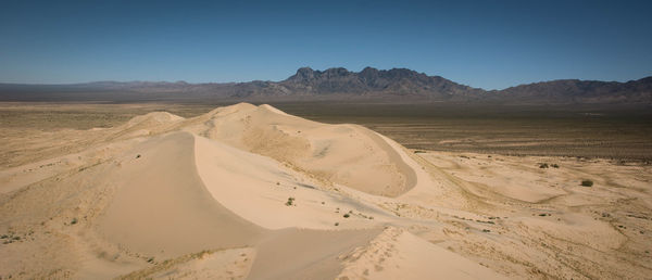 Scenic view of arid landscape at mojave desert against sky