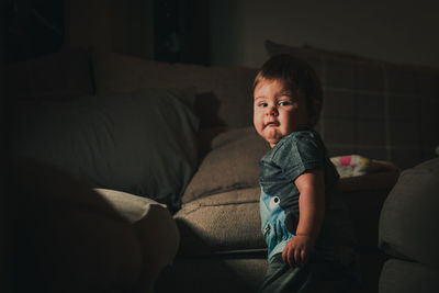 Portrait of cute boy on sofa at home