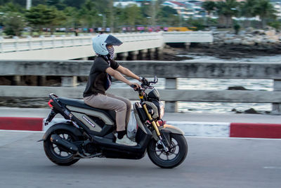 Rear view of man riding bicycle on road