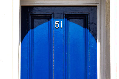 House number 51 on a blue wooden front door 