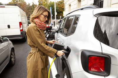 Woman charging electric car