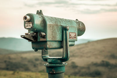 Close-up of coin-operated binoculars against sky