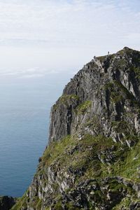 Scenic view of sea by cliff against sky