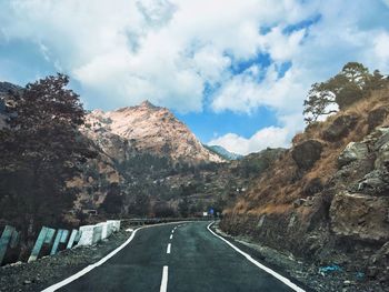 Road amidst trees against sky