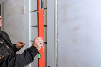 Man with level measurement tool working at construction site