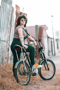 Vintage portrait of beautiful woman riding bicycle