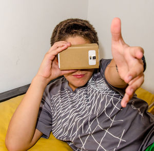 Close-up of boy gesturing while wearing virtual reality simulator