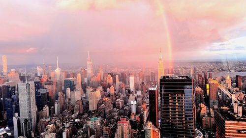 Panoramic view of buildings in city against cloudy sky