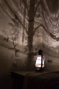 Close-up of electric lamp hanging on wall at home