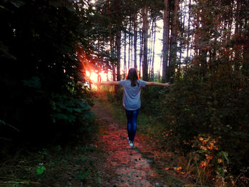 Rear view of woman walking in forest