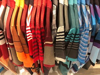 Multi colored t-shirts hanging at store for sale