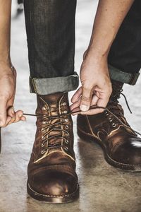 Low section of man tying shoelace