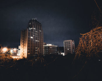 Illuminated cityscape against sky at night