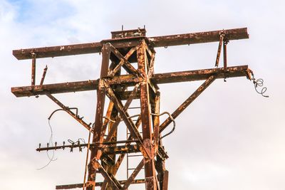 Low angle view of rusty metallic structure against sky