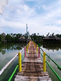 Boardwalk amidst trees against sky