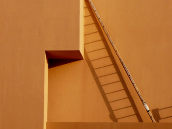 Low angle view of ladder against wall