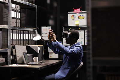 Rear view of man using mobile phone in office