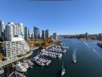 High angle view of city by sea against clear blue sky