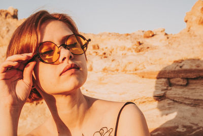 Portrait of young woman wearing sunglasses on beach