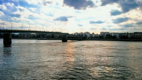 Bridge over river in city against sky