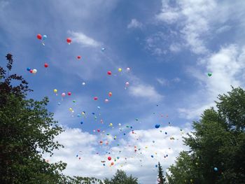 Low angle view of balloons flying against sky