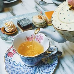 Close-up of cropped hand pouring tea at table