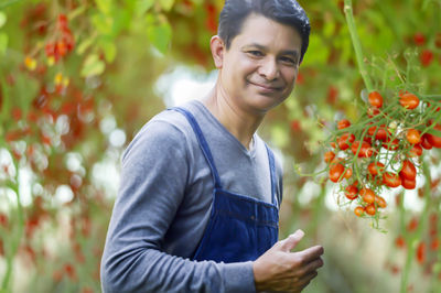 Portrait of smiling man standing against plants