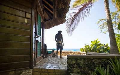 Rear view of man standing by swimming pool