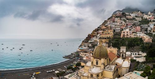 High angle view of townscape by sea against sky