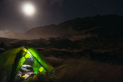 Tent on field against sky at night