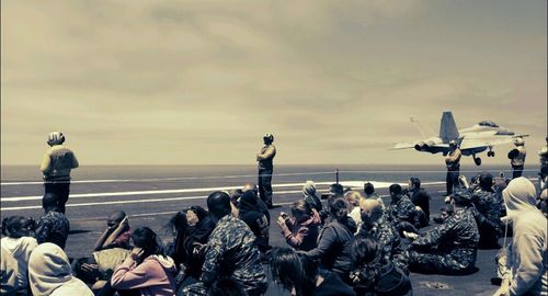 People looking at sea against sky