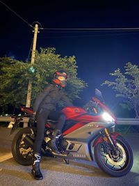 Man riding motorcycle on road at night