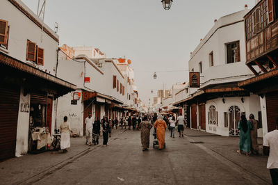 People on street amidst buildings in city