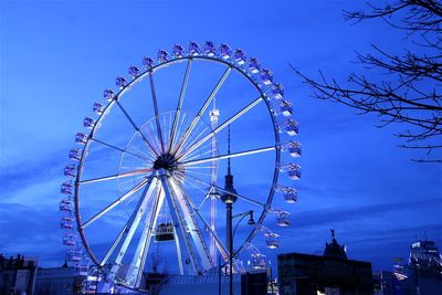 Low angle view of ferris wheel against blue sky