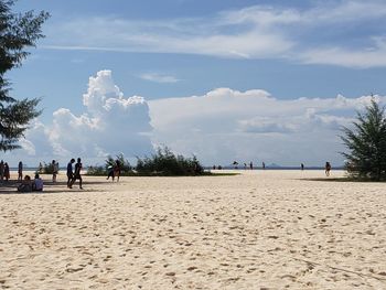 People on beach against sky