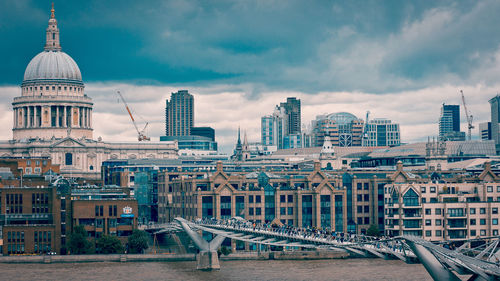 Modern buildings in city against cloudy sky