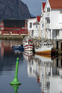 Sailboats moored on lake against buildings