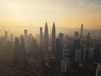 Buildings in city against sky during sunset