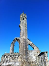 Low angle view of historical cathedral ruin against clear blue sky
