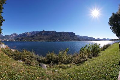 Scenic view of lake against blue sky on sunny day