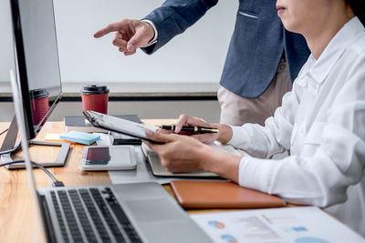 Midsection of man using laptop on table