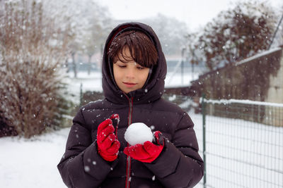 Portrait of young woman standing on snow