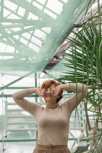 A beautiful plus size girl enjoying standing among the green plants