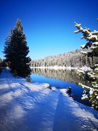 Scenic view of frozen lake against blue sky