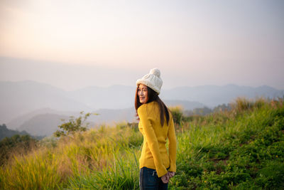 Woman standing on field against sky