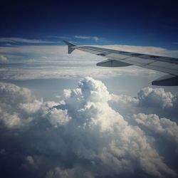 Cropped image of airplane flying over clouds