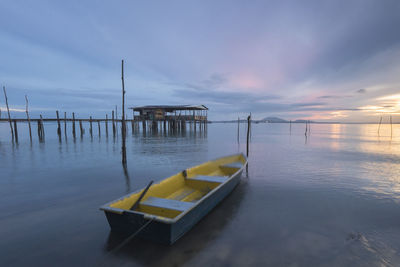 Pier over sea against sky during sunset